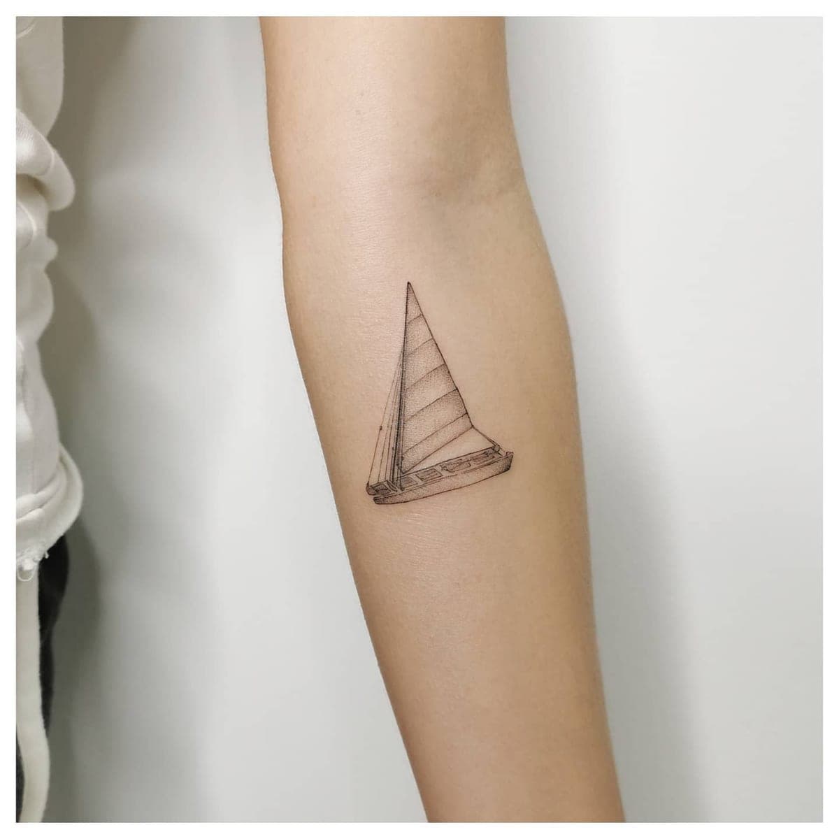Tatuaje de línea fina: patí català en el antebrazo