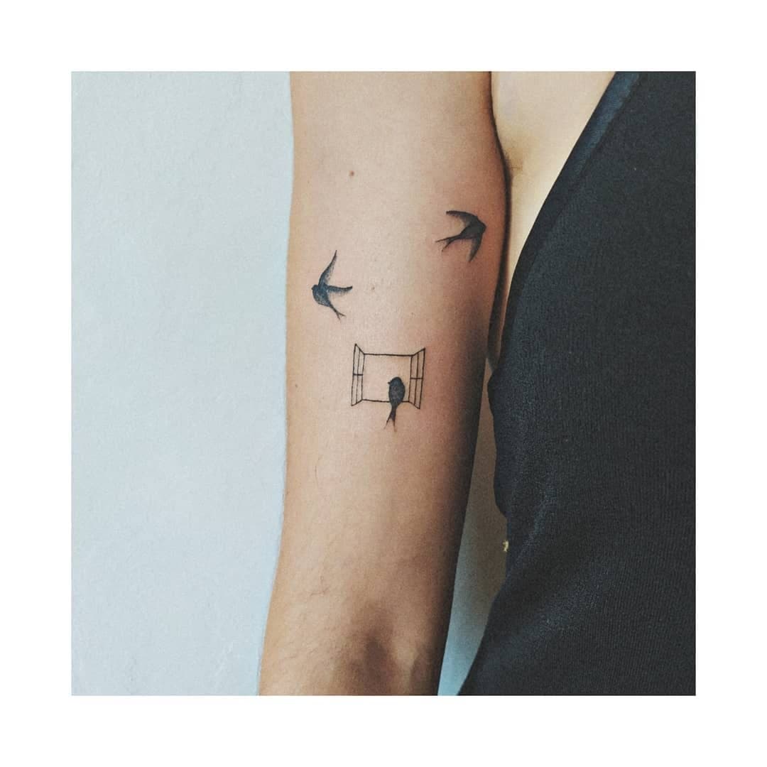 Tatuaje de línea fina: golondrinas y ventana en el brazo